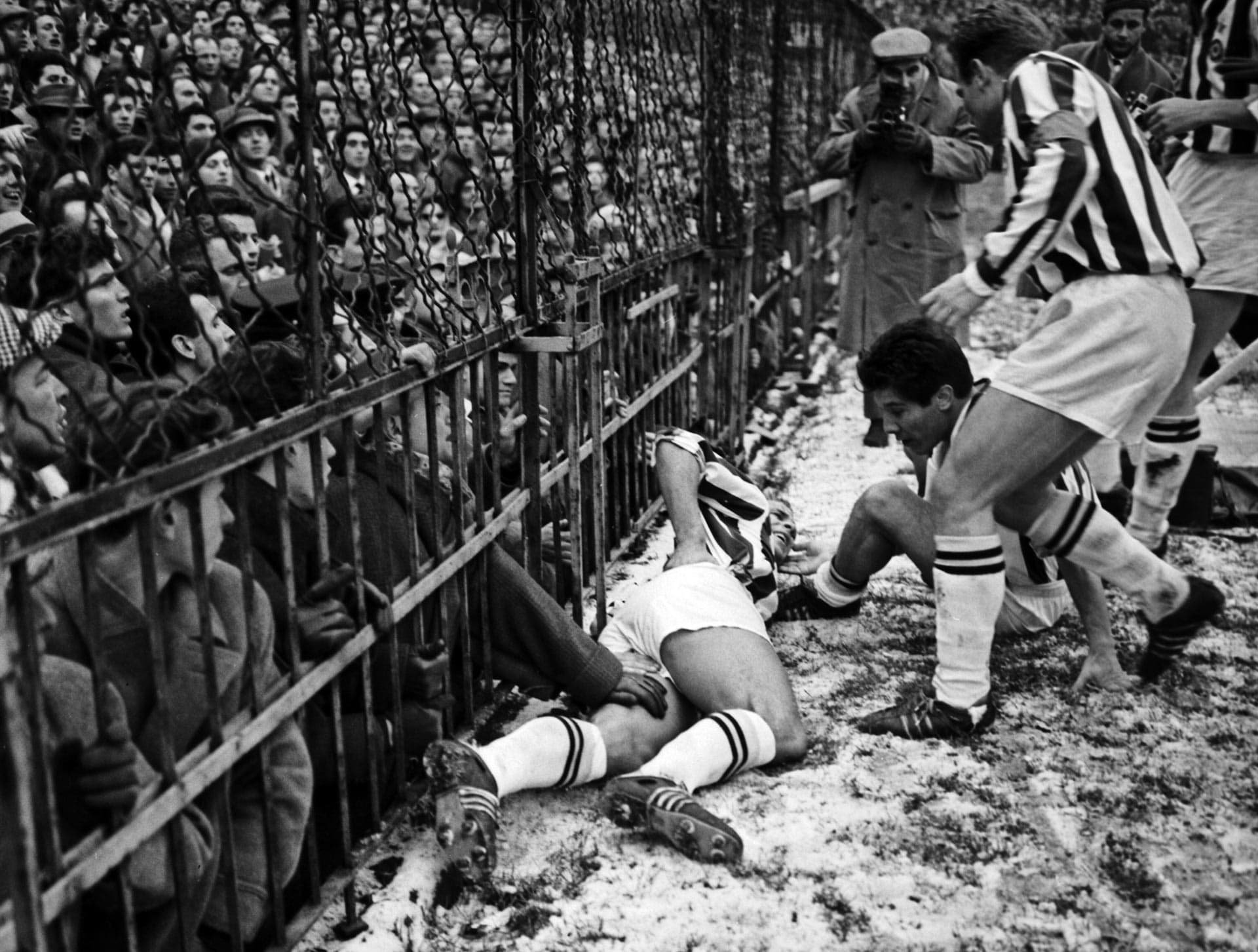 Giampiero Boniperti y Omar Sívori ayudan a John Charles tras su lesión durante el partido AC Milan - Juventus FC, en la última temporada del Trío Mágico (1960/61)./ Archivio Farabola